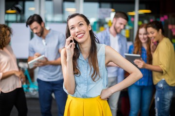Smiling female executive talking on mobile phone