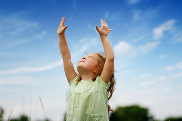 Cute little girl on the meadow in spring day