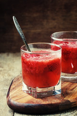 Strawberry jelly in glasses with spoons, vintage wooden background, selective focus