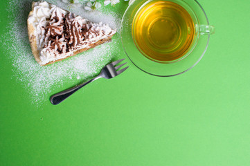cake with tea on green background