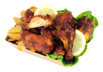Chicken wings and potato wedges in a cardboard take away tray isolated on a white background