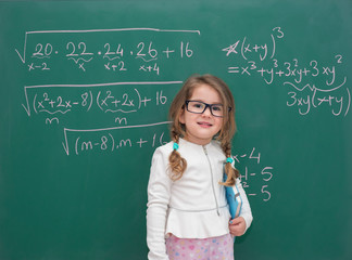 little kid girl teaching in front of the green board