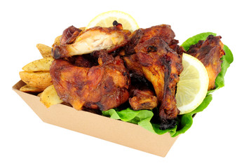 Chicken wings and potato wedges in a cardboard take away tray isolated on a white background