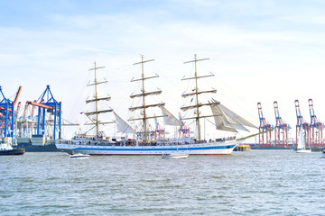 Hamburg harbor, birthday parade with various ships. View to Hamburg harbor with harbor cranes.