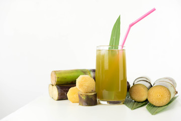 Fresh sugar cane juice in glass on white background