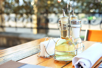 Obraz na płótnie Canvas Salt, pepper, oil and vinegar with napkins on the table