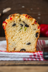 Close up of savory bread with bell pepper, herbs, cheese and olives on a napkin. Rustic style.