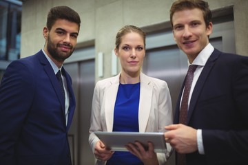 Portrait of businesspeople holding digital tablet