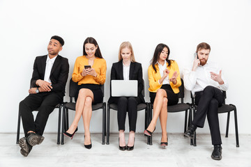 Colleagues sitting in office. Looking aside.