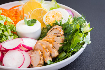 Fresh vegetable salad on a white plate with sauce. 