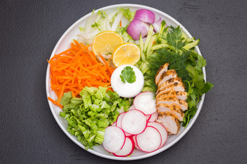 Fresh vegetable salad on a white plate with sauce. 