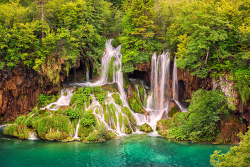Beautiful waterfall in a green forest, Plitvice Lakes National Park, famous tourist destination in Croatia, nature background suitable for wallpaper, cover or guide book