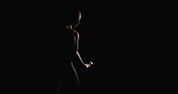 Athletic woman training with dumbbells black background sport gym fitness