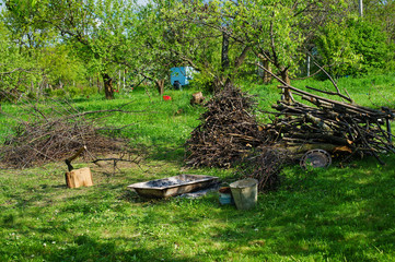 Coutryside garden view, fireplace with firewood and axe tool for chopping trees 