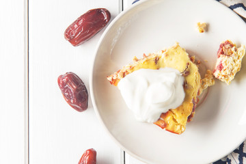 Casserole of cottage cheese with dates on a white wooden background, sugar-free, horizontal, soft focus, top view
