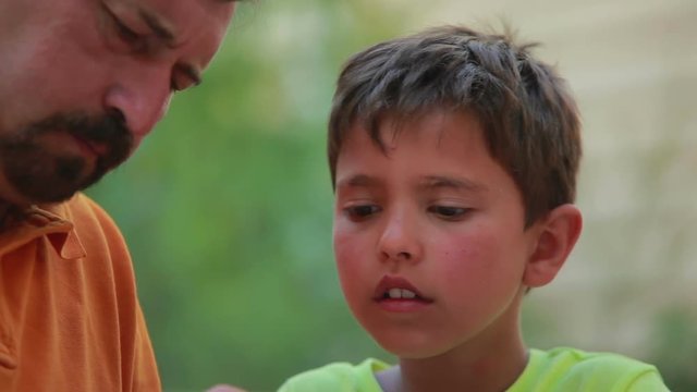 Close-up face of boy and man collect model from the designer outdoors in summer day