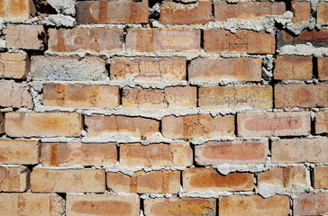 Badly laid brick wall with cracks and gaps