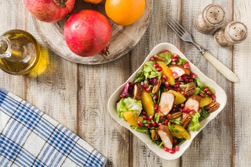 Spring salad with chicken, pomegranate, orange, pecan nuts and honey.