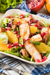 Spring salad with chicken, pomegranate, orange, pecan nuts and honey.