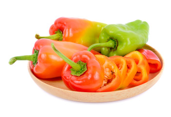 Sweet pepper in wooden dish isolated on  white background