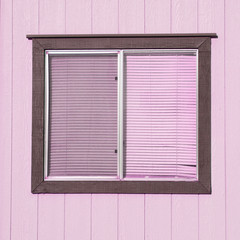 old window with plastic window blinds with wood walls.