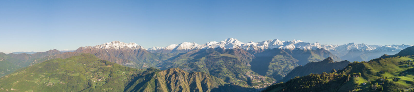 Drone aerial view to the Orobie Alps and Formico pick in a clear and blue day. Fresh snow on the top of mountain in spring. Panorama at Farno Mountain, Bergamo, Italy. © Matteo Ceruti
