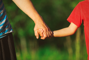 grandmother and grandson holding hands in nature