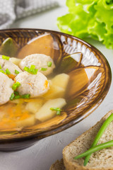 Healthy chicken soup with meatballs, slices of bread and lettuce leaves. Healthy dinner.