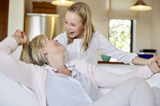 Little girl having fun with her grandmother at home