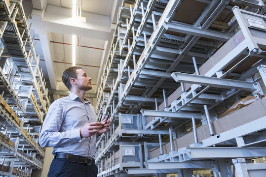 Man in factory warehouse looking at shelves