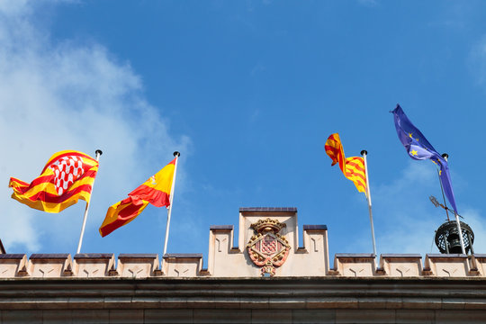 Catalan, Spanish and European flags waving on the roof of the Town Hall of Girona