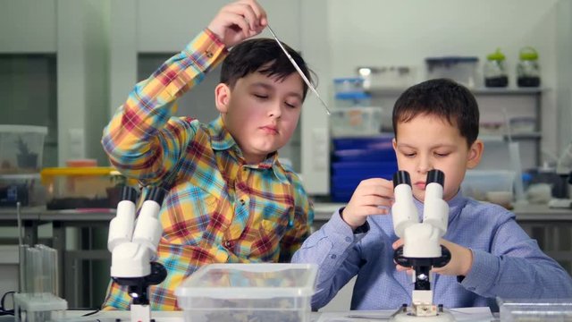 The mutual work of young scientists boys in the laboratory. Close-up. 4K.