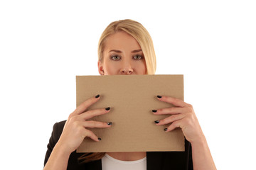 Eine Frau verdeckt ihr Gesicht zur Hälfte mit einem unbeschrifteten Pappschild