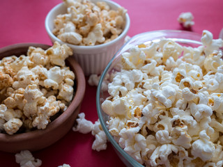 Many flavors of Poporn in bowls on red