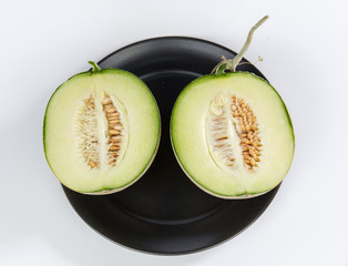 
Cantaloupe melon slices sitting on black plate 
