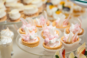 glass stand with cupcakes on a wedding candy bar table