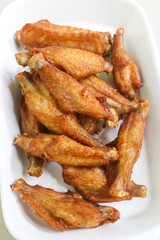 Closeup of little fried chicken wings on the disk