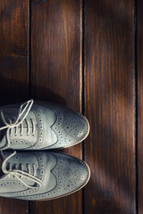 Grey oxford shoes on wooden background