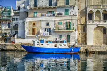 Fototapeta na wymiar Blue boats in seaport of Monopoli, Italy