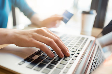 Hands typing on computer keyboard while making online payment from credit card