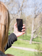 The girl is making a selfie in the park