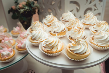 glass stand with cupcakes on a wedding candy bar table