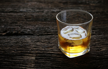 whiskey with ice cubes served on Old wood table
