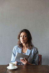 Fototapeta premium Gorgeous woman sitting indoors using tablet computer.