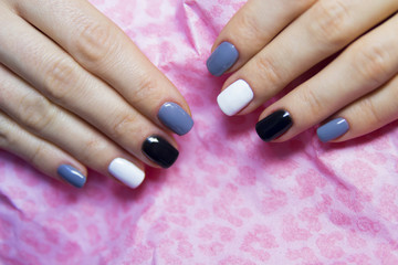 Obraz na płótnie Canvas Black, grey and white polished nails on pink background