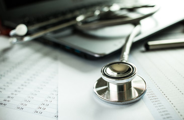 Medicine doctor's working on laptop computer and hand doctor on background. Focus on stethoscope