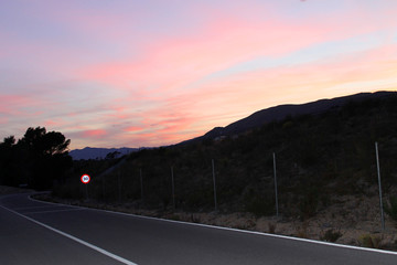 Atardecer dramatico en la montañacarretera. Colores rojos y anaranjados.