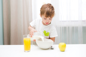 Little boy having breakfast in the kitchen.