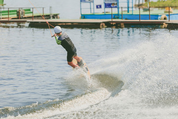 A young man practiced jumping at Wakeboarding. Photo processing grain.