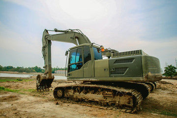 Fototapeta premium Excavator or backhoe at the construction site with Pale sky